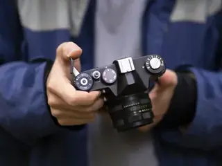 Technician adjusting the settings of a mirrorless camera